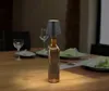 A table setting with plates, glasses, and a bottle lamp. Produktbild-Vorschau