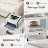 A split image showing a printer on a small table on the left, and a storage shelf with books and decorative items on the right. Text overlays indicate 'Storage Shelf' and 'Spacious Top'. Produktbild-Vorschau