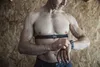 A man wearing a heart rate monitor chest strap checks his smartwatch. Anteprima dell’immagine prodotto