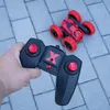 A hand holding a remote control for a red toy car. Produktbild-Vorschau