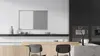A modern kitchen with a counter and chairs, featuring a wall-mounted combination board. Produktbild-Vorschau