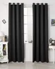A pair of black curtains hanging in front of a window, with a dresser and a small table visible on either side. Produktbild-Vorschau