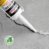 A tube of sealant is being used to fill a crack in a concrete surface. Produktbild-Vorschau
