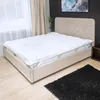 A mattress topper is placed on a bed in a bedroom setting. Produktbild-Vorschau