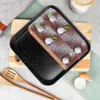 A chocolate cake with blueberries and powdered sugar on a baking tray, placed on a wooden board, with kitchen utensils and an eggshell nearby. Náhľad obrázku produktu