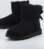 A pair of black Ugg boots with a bow on the back, shown on a white background. Produktbild-Vorschau