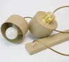 Two beige pendant light fixtures with gold accents and visible light bulbs, lying on a white surface. Produktbild-Vorschau