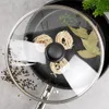 A close-up overhead view of a glass lid on a frying pan, with pasta nests, bay leaves, and peppercorns arranged on the pan. Podgląd zdjęcia produktu