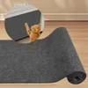 A rolled-up gray carpet is shown on a wooden floor, with a close-up inset showing a ginger cat playing with the carpet. Produktbild-Vorschau