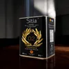 A black metal tin of olive oil is placed on a wooden table with soft lighting. Produktbild-Vorschau
