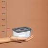 A hand holds a glass storage container next to a ruler showing measurements. Náhled obrázku produktu