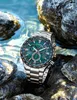 A watch resting on rocks near water. Náhled obrázku produktu