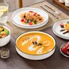 A table setting with various dishes including soup, pasta, salad, and dessert, along with a glass of water. Náhled obrázku produktu