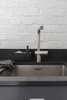 A close-up shot of a kitchen sink area with a faucet, soap dispenser, and sponge holder. Produktbild-Vorschau