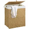 A woven laundry basket with a lid and a white towel draped over the side. Náhľad obrázku produktu