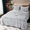 A neatly made bed with a light gray plush blanket and matching pillows. Náhled obrázku produktu