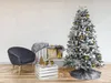 A decorated Christmas tree with ornaments and a chair next to it, set against a tiled wall. Podgląd zdjęcia produktu