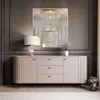 A modern living room with a beige sideboard, a lamp, a mirror, and decorative items. Produktbild-Vorschau