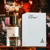 A perfume bottle and its box are displayed on a shelf with a blurred background. Produktbild-Vorschau
