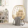 A rattan egg chair with cushions and a blanket is placed in a room next to a white bookshelf. Produktbild-Vorschau
