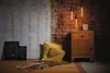 A vintage-style bedroom corner with a bedside table, pillows, and artwork. Anteprima dell’immagine prodotto