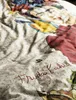 A close-up view of a bedding set with a colorful print and the signature "Frida Kahlo" written on it. Produktbild-Vorschau