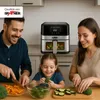 A family is preparing food in a kitchen, with an air fryer prominently displayed. Produktbild-Vorschau