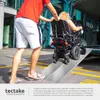 A person is pushing a wheelchair up a ramp towards a vehicle. Náhled obrázku produktu