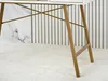 Close-up view of the lower part of a desk, showing its golden legs and a white textured rug. Voir les images du produit