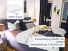 A neatly made bed with white bedding featuring a deer motif, pillows, and a wooden tray with a book and candles. Produktbild-Vorschau