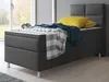 A bed with bedding and pillows in a room with a window. Produktbild-Vorschau