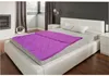 A bedroom scene with a bed made up with a purple comforter. Produktbild-Vorschau