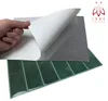A hand is peeling the protective film off a sheet of self-adhesive 3D wallpaper panels. The panels are green and arranged in a grid. Produktbild-Vorschau