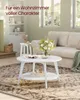 A white round coffee table with a shelf is placed on a patterned rug in a living room. A vase of flowers sits on the table, and a sofa is visible in the background. Produktbild-Vorschau