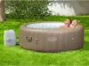 A couple relaxing in an inflatable hot tub in a backyard setting. Produktbild-Vorschau