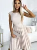 A woman wearing a beige dress and holding a clutch. Produktbild-Vorschau