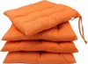 A stack of four orange seat cushions on a white background. Produktbild-Vorschau