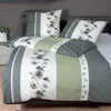 A neatly made bed with a duvet and pillows, showcasing a green and white floral bedding set. Produktbild-Vorschau