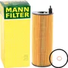 A product shot of a Mann Filter oil filter and its packaging, along with a gasket and a smaller copper washer. Podgląd zdjęcia produktu