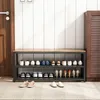A shoe rack with shoes on it, placed in a hallway next to a door and a cabinet. Podgląd zdjęcia produktu