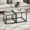 A set of two square nesting coffee tables with white tops and black metal frames, placed on a rug in a living room setting. Voir les images du produit