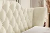 A close-up view of a tufted beige velvet headboard of a bed. Produktbild-Vorschau