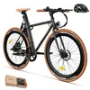 A black electric bicycle with tan accents, presented on a white background. A black helmet is placed to the upper right of the bicycle. A small gift box is in the lower left corner. Produktbild-Vorschau
