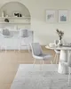 A modern dining area with light green walls and a white arched shelf. Includes bar stools and dining chairs around a round table. Náhled obrázku produktu
