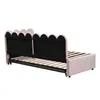 The back view of a pink upholstered daybed with a scalloped headboard and an extended wooden slatted base. Podgląd zdjęcia produktu