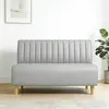 A grey sofa in a room with a white wall and a plant. Produktbild-Vorschau