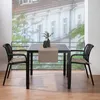 A table and chairs set on a balcony with a view of buildings. Produktbild-Vorschau