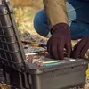 A person wearing gloves is organizing fishing lures in a black case. Produktbild-Vorschau