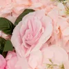 A close-up view of artificial pink roses and green leaves. Podgląd zdjęcia produktu