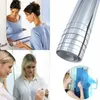 A collage of images showing a woman applying a reflective film to a mirror, a roll of reflective film, and two women looking at a blue reflective film. Produktbild-Vorschau